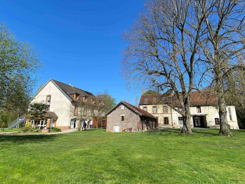 Un pré ensoleillé sur lequel se trouvent les batiments de l'auberge qui nous accueille