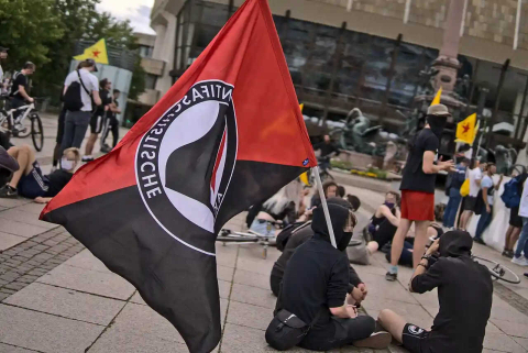 Photo du drapeau d'Autistici/Inventati tenu par des manifestants. CC BY-SA 2.0 Gregor Wünsch via Wikimedia Commons