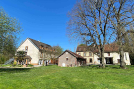 Un pré ensoleillé sur lequel se trouvent les batiments de l'auberge qui nous accueille